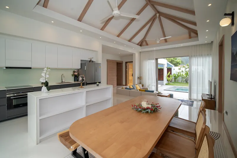 Dining table and kitchen opening onto the pool terrace